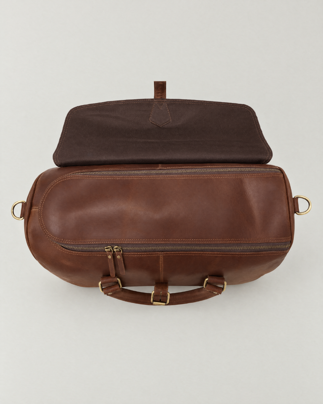 Top view of the Laylowe Parker tan leather weekender with its outer flap folded back to reveal the zip opening.