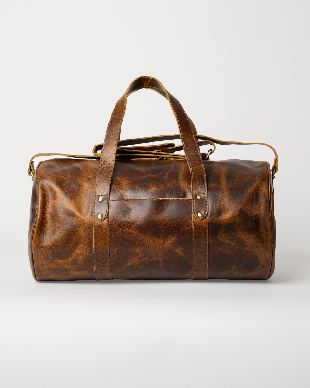 Laylowe Wells light brown full-grain leather weekender with a barrel-shaped body, flat carry handles and shoulder strap.