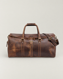 Front view of the Laylowe Rhodes large light brown leather travel bag showing its buckled flap and carry handles.