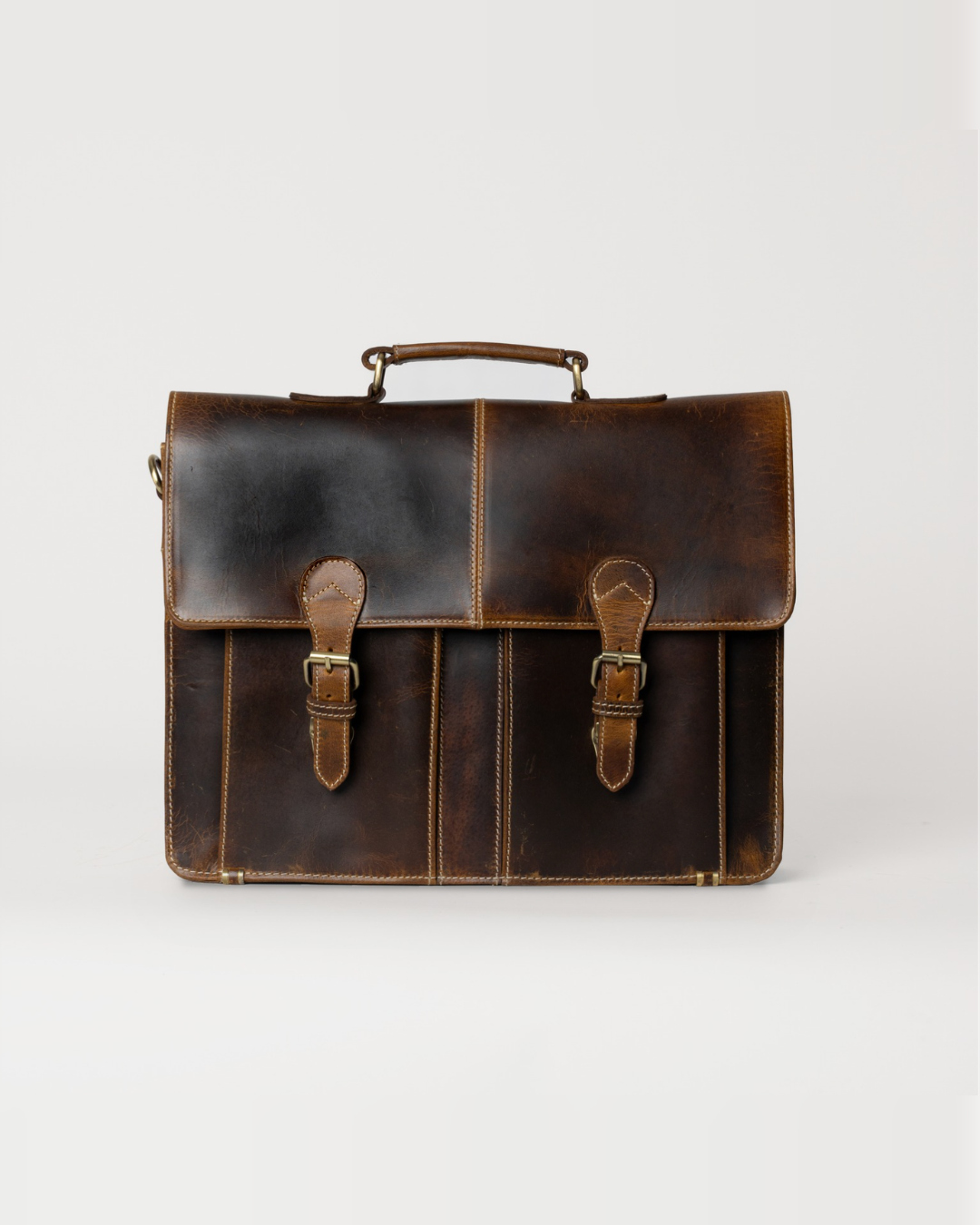 Front view of the Laylowe Grant brown leather briefcase with two buckle straps and a structured top handle.