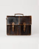 Front view of the Laylowe Grant brown leather briefcase with two buckle straps and a structured top handle.