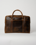 Front view of the Laylowe Reid dark brown leather briefcase with a horizontal zip pocket and rolled handles.