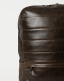 Laylowe Lane dark brown leather backpack detail showing the leather texture, front stitching and zip pocket.