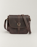 Front view of the Laylowe Cora dark brown leather satchel with its rounded flap and central ring buckle.