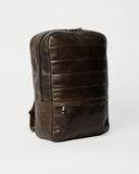 Angled front view of the Laylowe Lane dark brown leather backpack with its main zipper and lower front pocket.