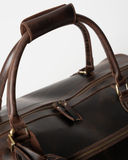 Close-up of the Laylowe Hayes dark brown leather weekender showing the handle wrap and double top zipper.