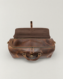 Top view of the Laylowe Rhodes light brown leather travel bag with its outer flap open and inner zipper closed.
