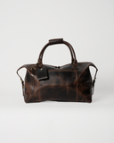 Front view of the Laylowe Hayes dark brown leather weekender with exterior zip pocket and hanging luggage tag.