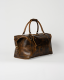 Laylowe Hayes light brown full-grain leather weekender, angled view with carry handles, luggage tag and side buckle.