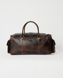 Rear view of the Laylowe Bennett dark brown leather travel bag showing rolled handles, center tab and mottled grain.