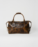 Front view of the Laylowe Hayes light brown leather weekender with two carry handles, zip pocket and luggage tag.
