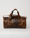 Rear view of the Laylowe Wells light brown leather duffle showing mottled leather panels and flat carry handles.