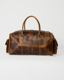 Laylowe Alden brown leather weekender shown from the back, with rolled handles, center tab and mottled leather.