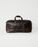 Laylowe Rowan dark brown full-grain leather duffle with a rectangular body, flat carry handles and front zip pocket.