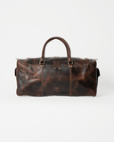 Rear view of the Laylowe Holden dark brown leather travel bag, showing carry handles and mottled leather panels.
