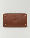 Bottom view of the Laylowe Parker tan leather weekender showing five metal feet and stitched leather panels.