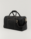 Laylowe Blake black leather duffle from the opposite side, showing the shoulder strap and rounded end panel.