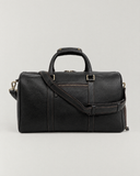Laylowe Blake black leather duffle viewed straight on with its padded shoulder strap across the front.