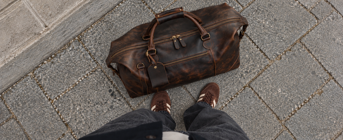 Close view of brown leather grain, stitching and zippers